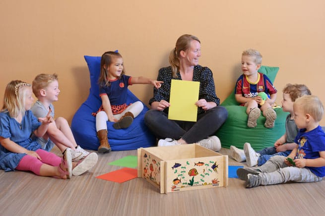 SWW locatie Klaverblad kinderen zitten in een kring op de grond met pedagogisch professional